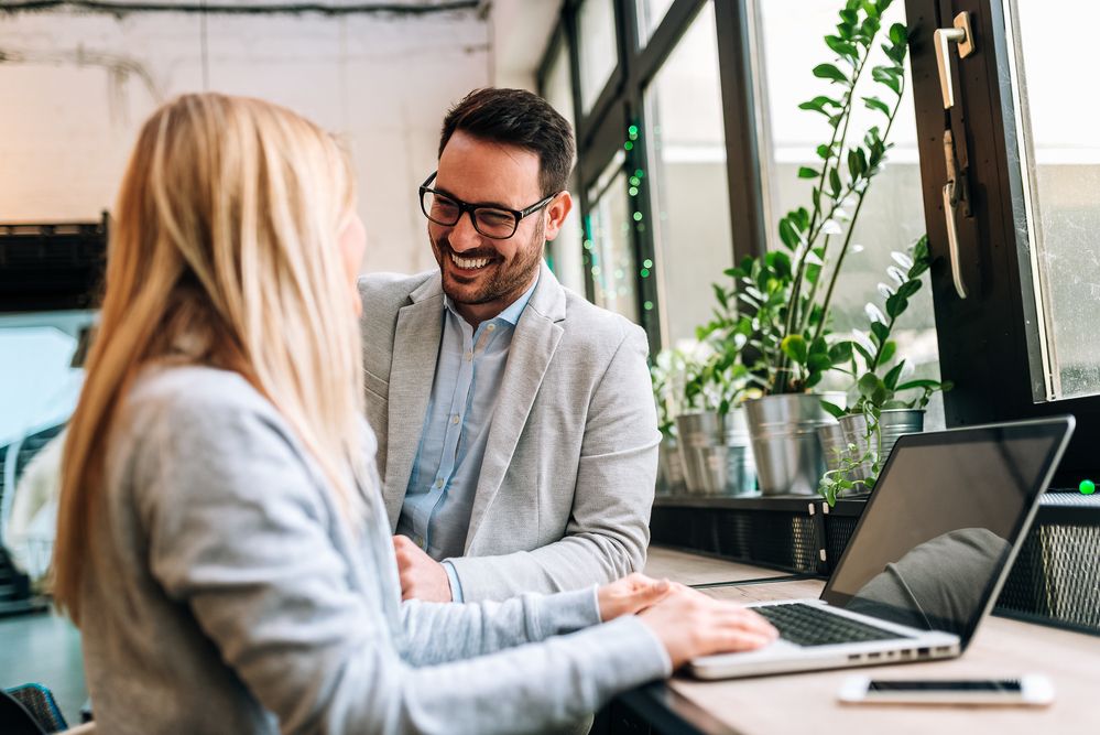 Man smiling at woman in an office space.